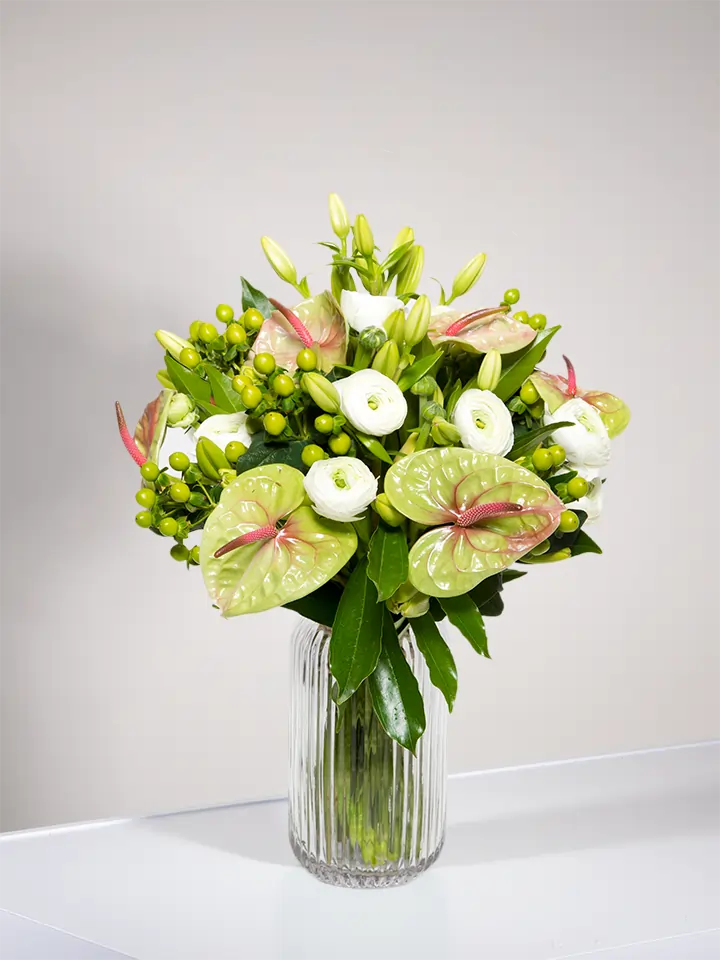 Bouquet di anthurium pistache ranuncoli bianchi e bacche verdi